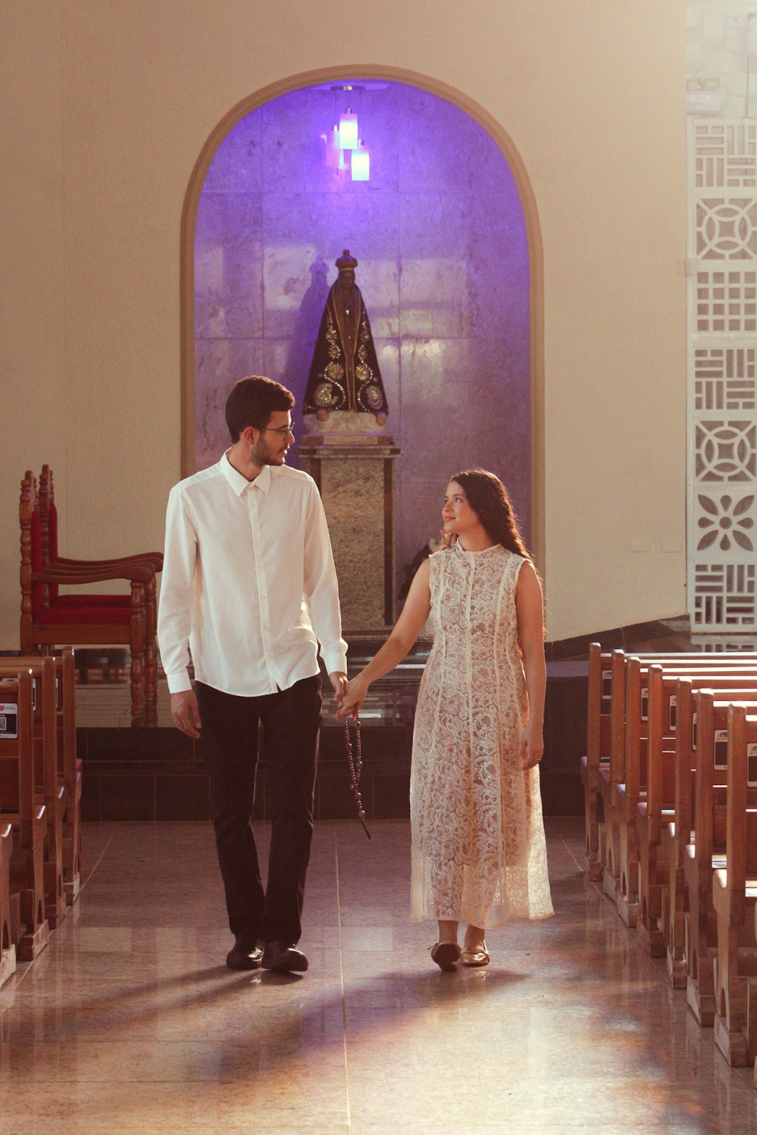 Ana e Thiago caminhando juntos pela nave da igreja